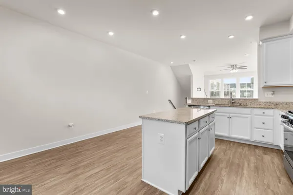 a kitchen with granite countertop sink and refrigerator