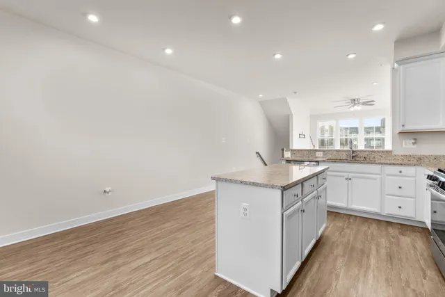 a kitchen with granite countertop sink and refrigerator