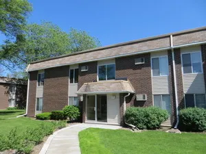 a view of a house with brick walls and a yard with plants