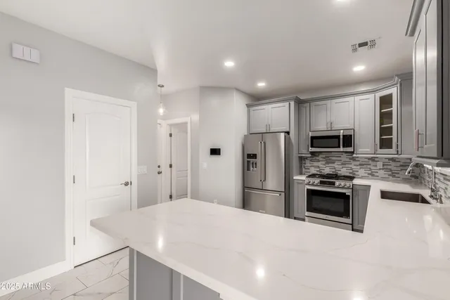 a kitchen with stainless steel appliances a stove sink microwave and refrigerator