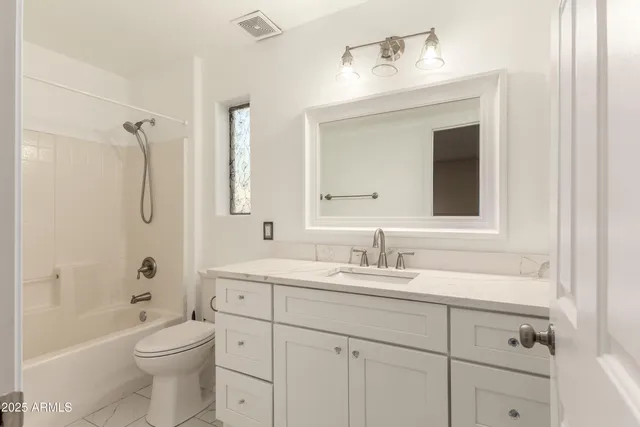 a bathroom with a toilet a sink a tub and mirror