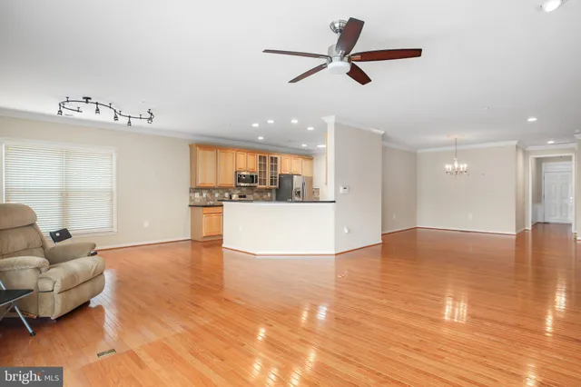a view of a living room a kitchen with furniture and a ceiling fan