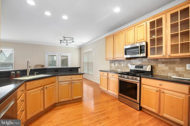 a large kitchen with stainless steel appliances granite countertop a stove and a sink