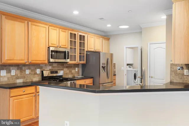 a kitchen with stainless steel appliances granite countertop a refrigerator and cabinets