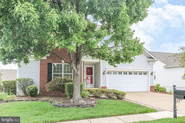 a view of a house with a yard and table and chairs under an umbrella