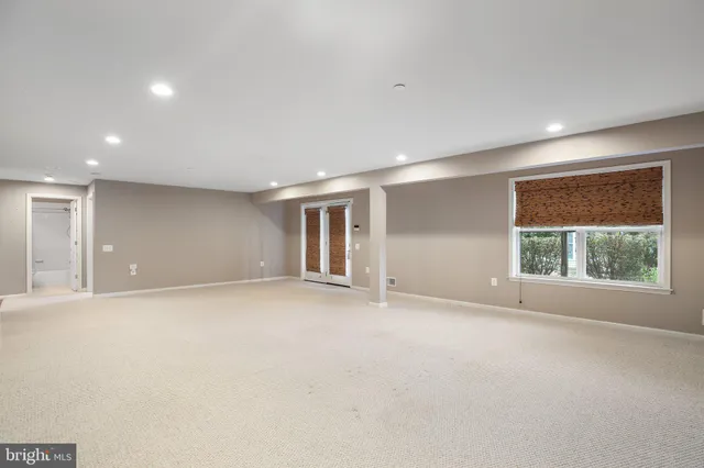 a view of an empty room with kitchen and a window