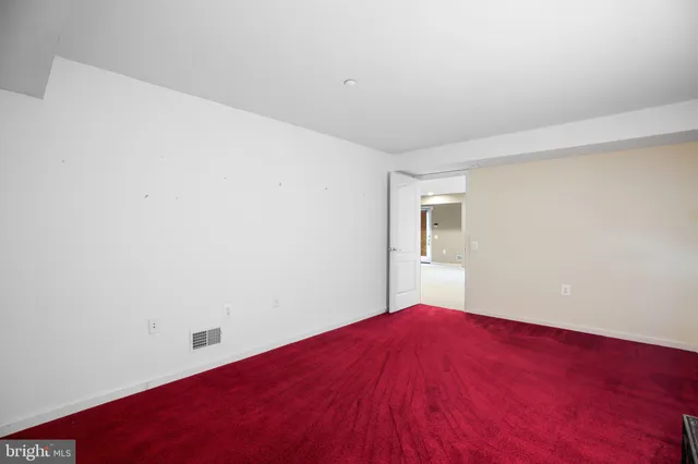 a view of a room with a bed and wooden floor