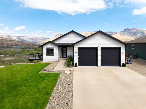 a front view of a house with a yard and garage