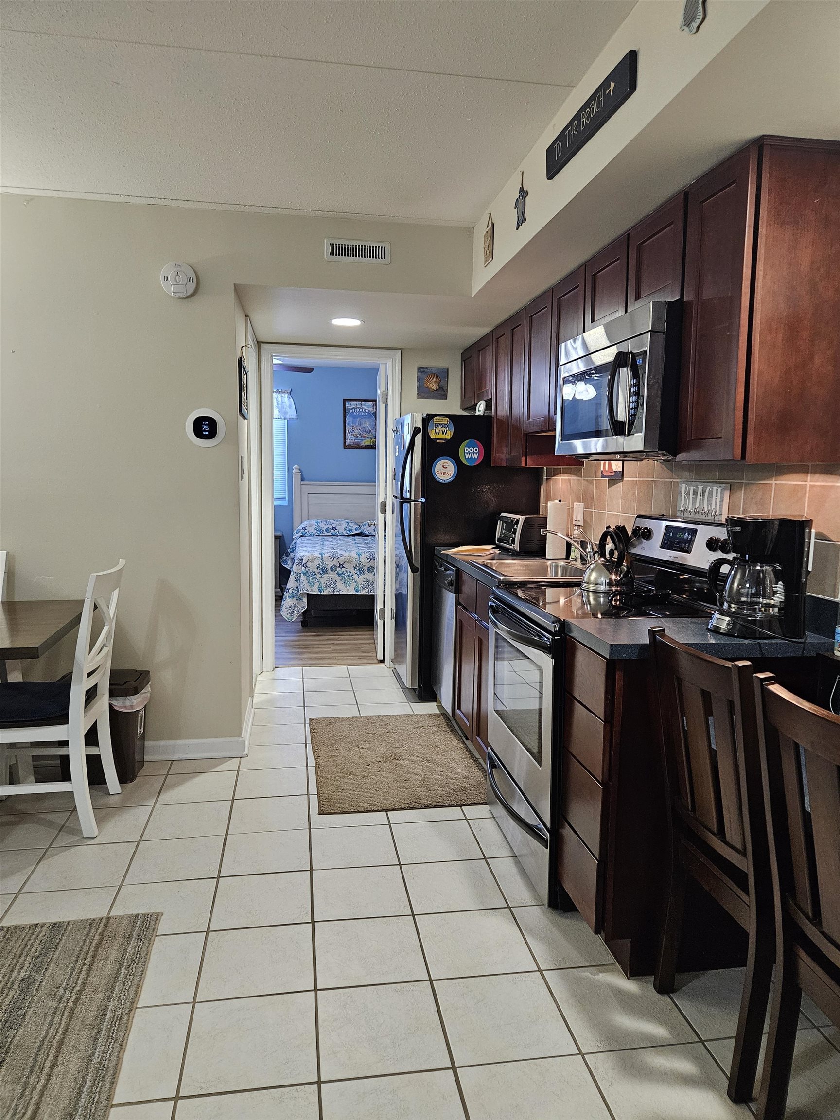 208 East Forget-Me-Not Road, Unit 111 Wildwood Crest, NJ 08260 - Photo 4 of 16 a kitchen with stainless steel appliances granite countertop a stove a sink and a refrigerator
