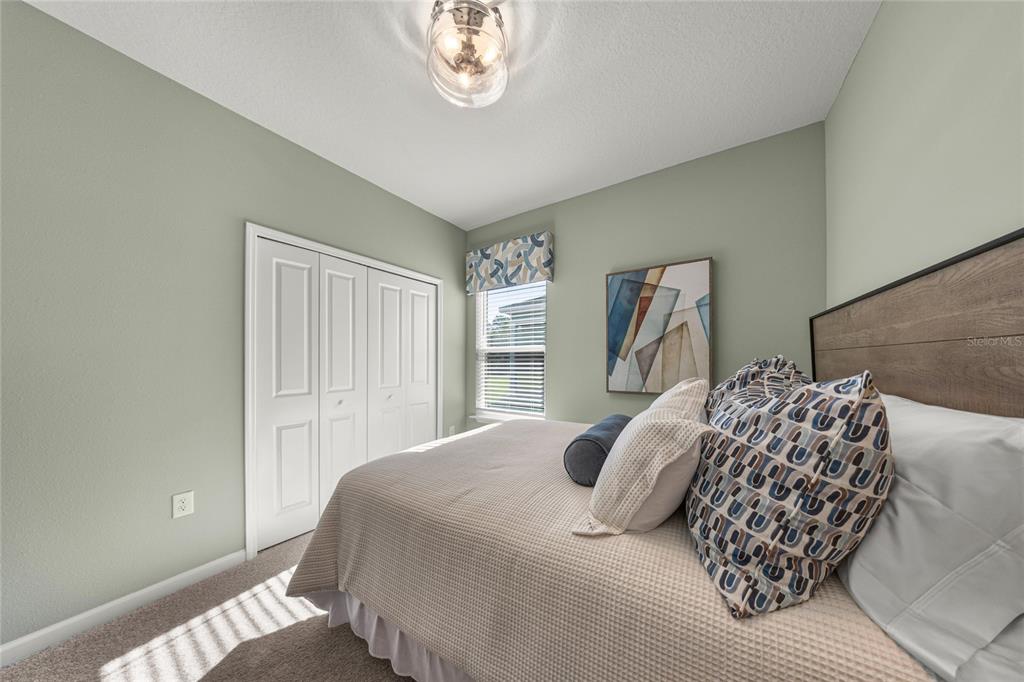 8904 Southwest 69th Terrace Ocala, FL 34476 - Photo 11 of 26 a bedroom with a large bed and a window