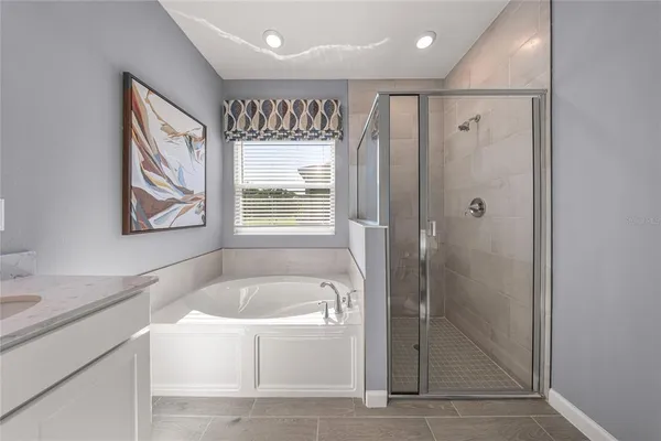 a bathroom with a granite countertop tub shower sink and mirror