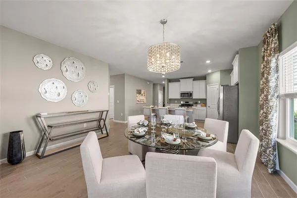 a view of a dining room with furniture a chandelier and wooden floor