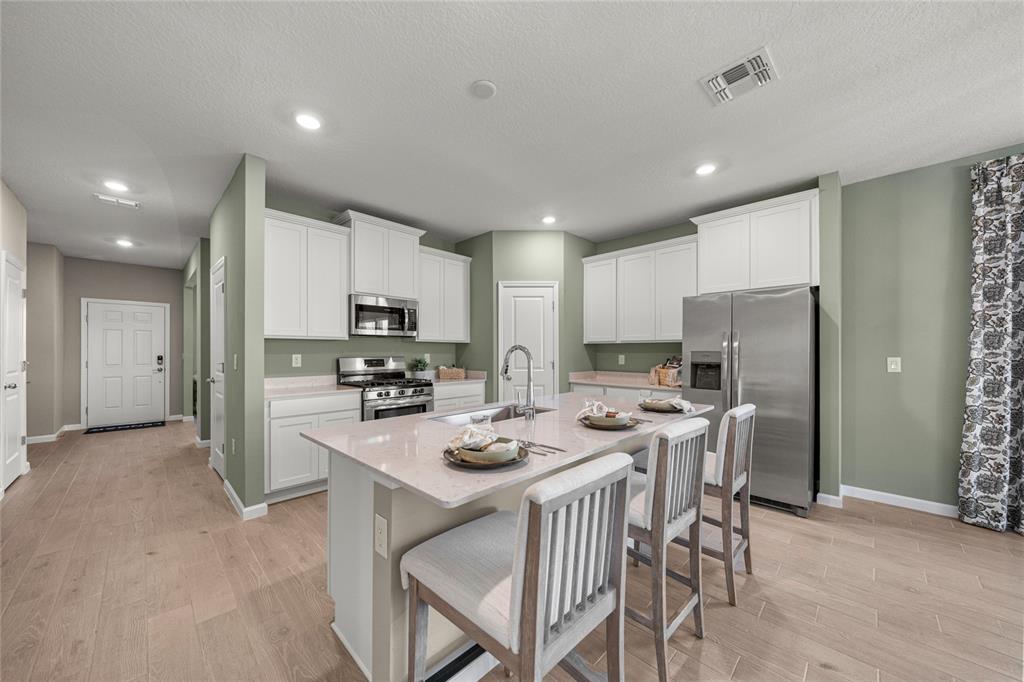 8904 Southwest 69th Terrace Ocala, FL 34476 - Photo 20 of 26 a kitchen with a refrigerator a stove a dining table and chairs