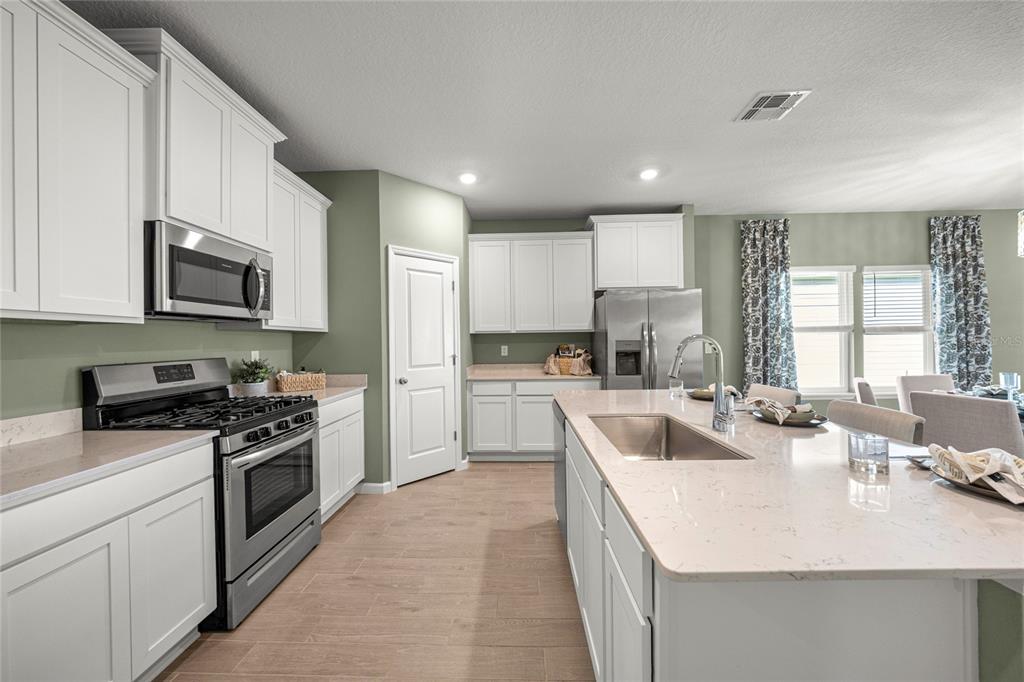 8904 Southwest 69th Terrace Ocala, FL 34476 - Photo 21 of 26 a kitchen with sink a stove top oven and cabinets