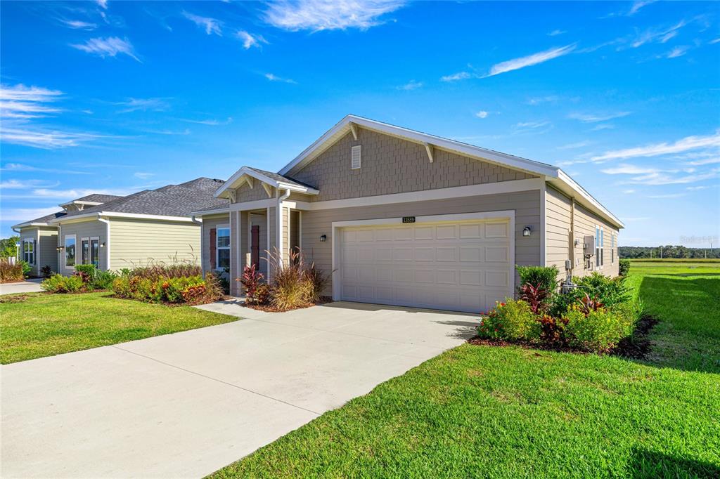8904 Southwest 69th Terrace Ocala, FL 34476 - Photo 6 of 26 a front view of a house with a yard and garage