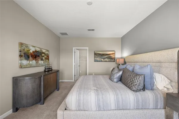 a bedroom with a large bed and a chandelier
