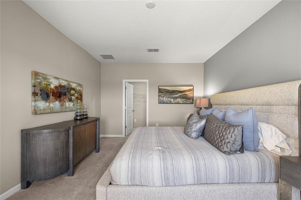 8904 Southwest 69th Terrace Ocala, FL 34476 - Photo 7 of 26 a bedroom with a large bed and a chandelier
