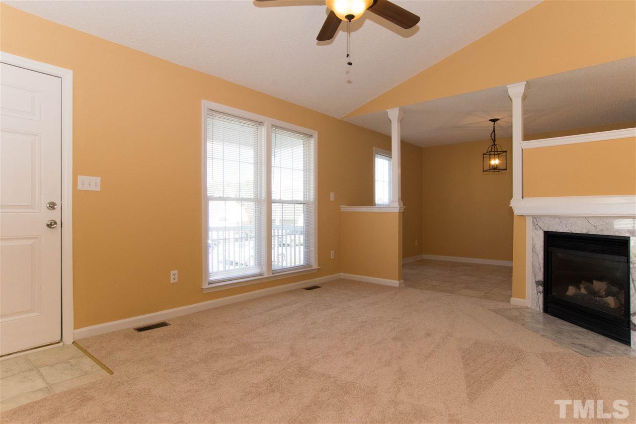 7112 Spanglers Spring Way Raleigh, NC 27610 - Photo 3 of 19 an empty room with windows and fireplace