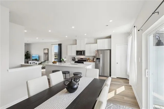 a view of a dining room kitchen with stainless steel appliances granite countertop a refrigerator and a stove top oven