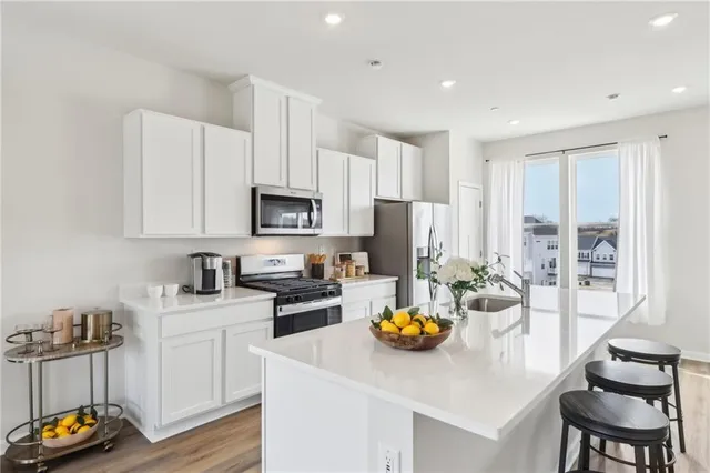 a kitchen with a sink a stove and white cabinets