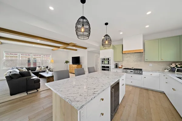 a large kitchen with a large counter space a sink stainless steel appliances and cabinets