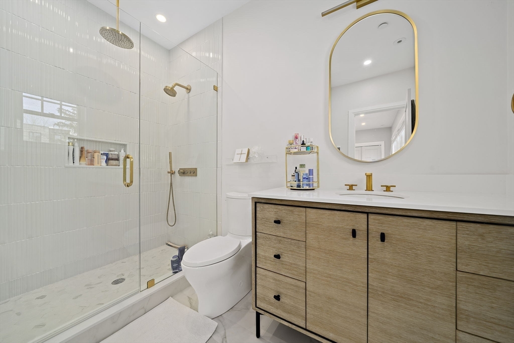 144 Linden Street, Unit 2 Wellesley, MA 02482 - Photo 13 of 28 a bathroom with a shower sink mirror and toilet