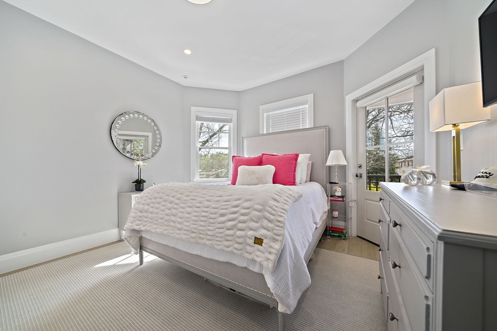 144 Linden Street, Unit 2 Wellesley, MA 02482 - Photo 14 of 28 a bedroom with a bed a chandelier and a window