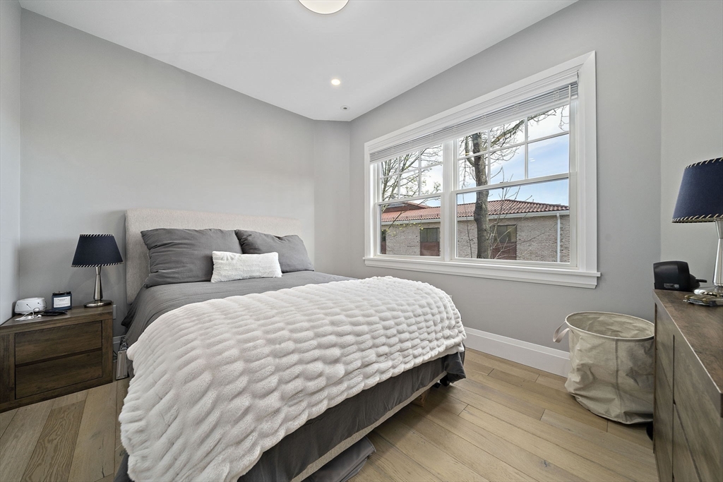 144 Linden Street, Unit 2 Wellesley, MA 02482 - Photo 16 of 28 a bedroom with a bed and wooden floor