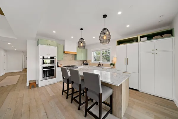 a kitchen with a table chairs refrigerator and cabinets