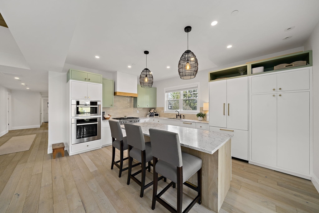 144 Linden Street, Unit 2 Wellesley, MA 02482 - Photo 2 of 28 a kitchen with a table chairs refrigerator and cabinets