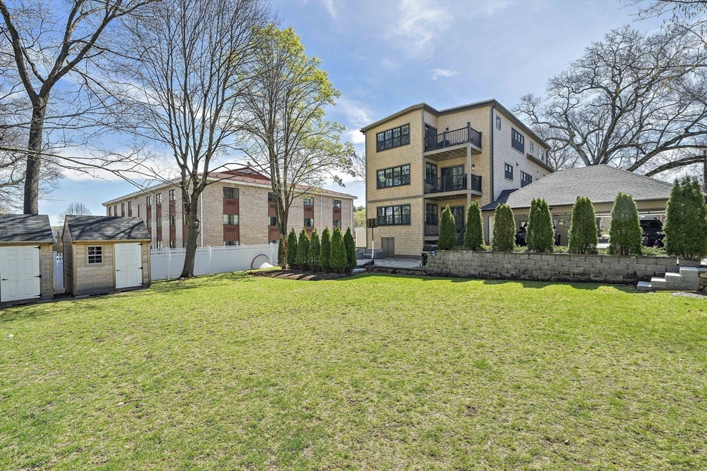 144 Linden Street, Unit 2 Wellesley, MA 02482 - Photo 25 of 28 a front view of a house with yard and green space