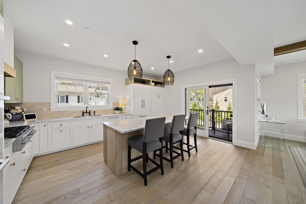 144 Linden Street, Unit 2 Wellesley, MA 02482 - Photo 3 of 28 a kitchen with white cabinets a sink dining table and chairs