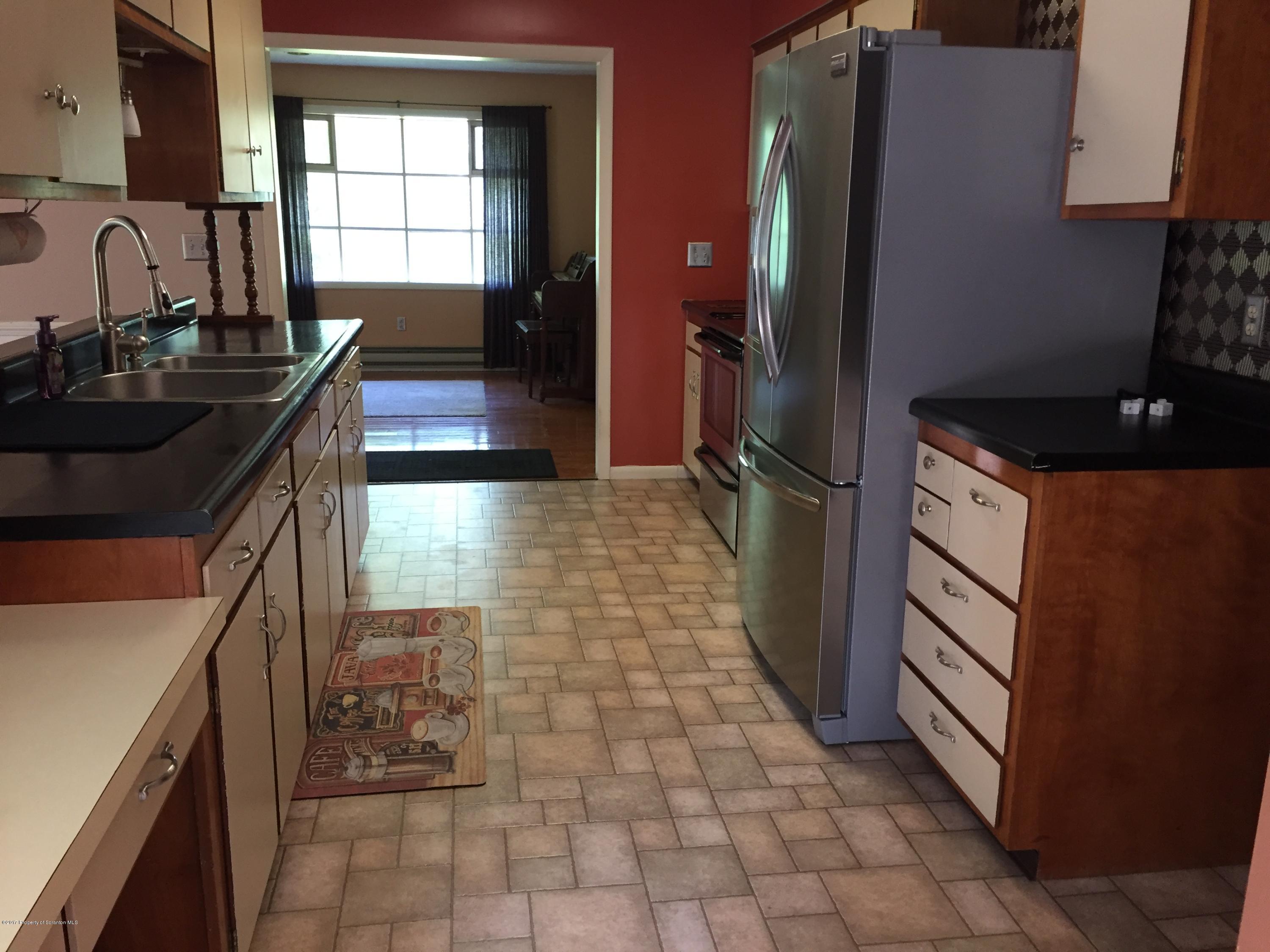 154 Hall Road Meshoppen, PA 18630 - Photo 9 of 35 a kitchen with granite countertop a refrigerator a stove a sink and a window
