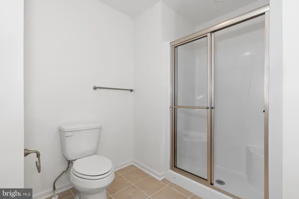 a bathroom with a granite countertop toilet and a sink