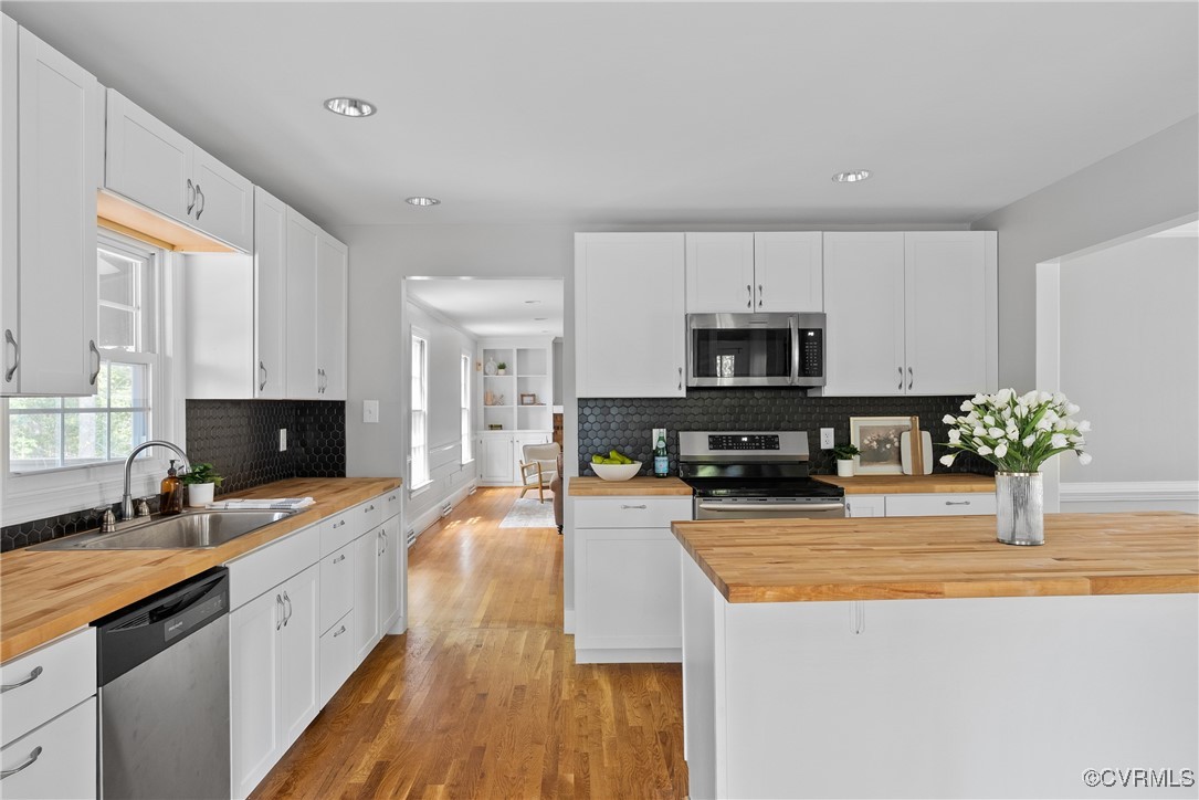 3600 Stoney Ridge Road Midlothian, VA 23112 - Photo 13 of 43 a large kitchen with stainless steel appliances granite countertop a stove top oven a sink dishwasher a dining table and chairs with wooden floor