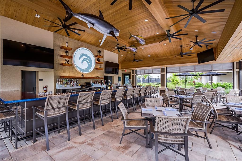 15324 Lucerna Street, Unit 201 Naples, FL 34114 - Photo 18 of 34 Dining room with beam ceiling, high vaulted ceiling, wood ceiling, and indoor bar