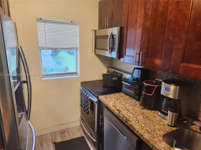a kitchen with stainless steel appliances granite countertop a refrigerator stove and sink