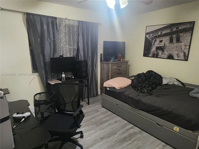 a bedroom with a bed chair and a desk