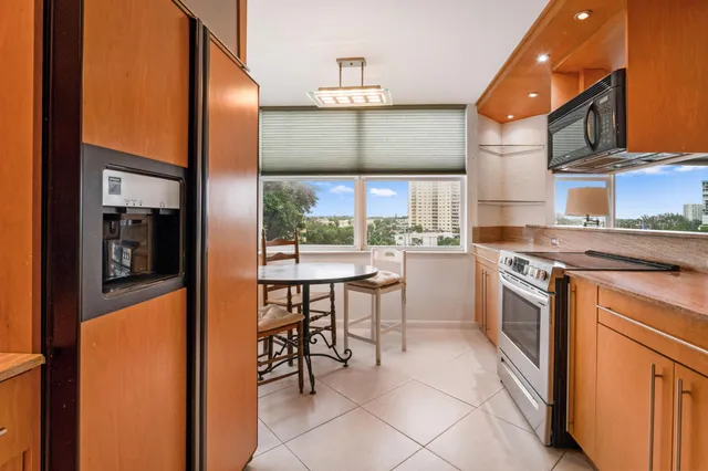 a kitchen with stainless steel appliances granite countertop a stove top oven a sink and a refrigerator