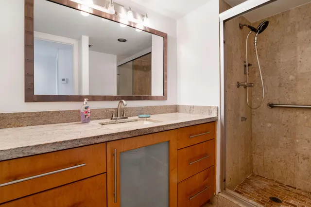 a bathroom with a granite countertop sink and a mirror
