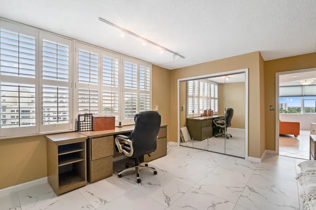 a view of a workspace with furniture and a window
