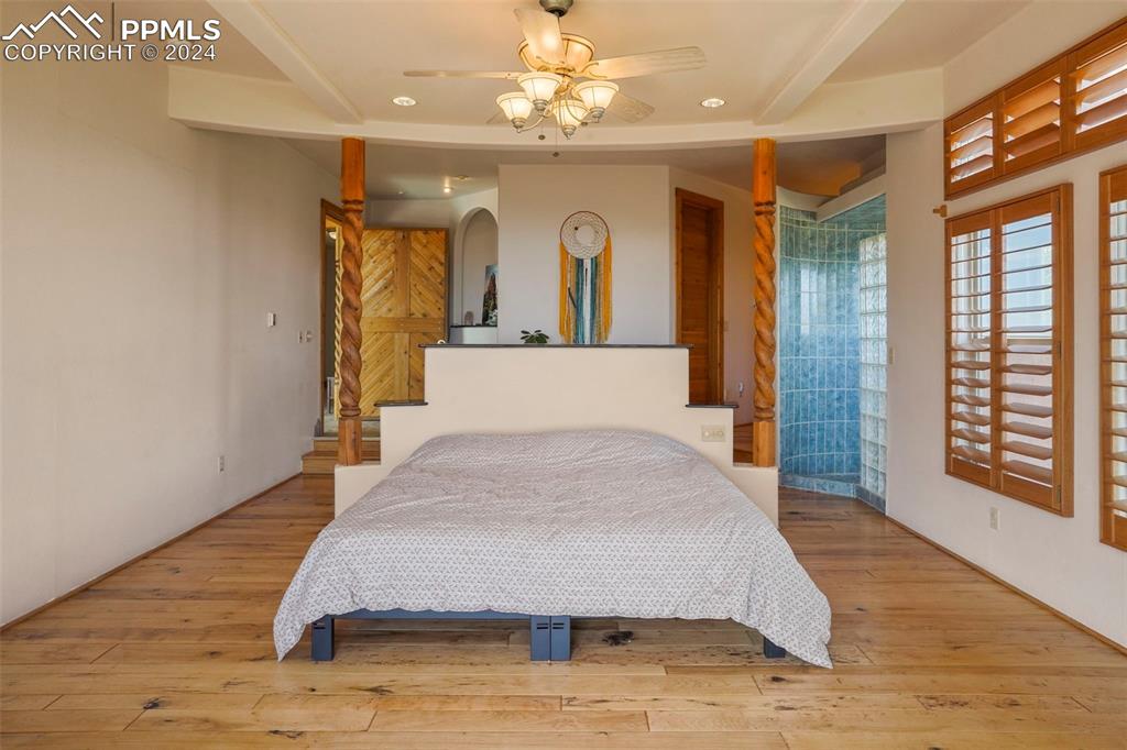 915 Oak Ridge Road Manitou Springs, CO 80829 - Photo 19 of 50 a bedroom with a large bed chandelier and a window