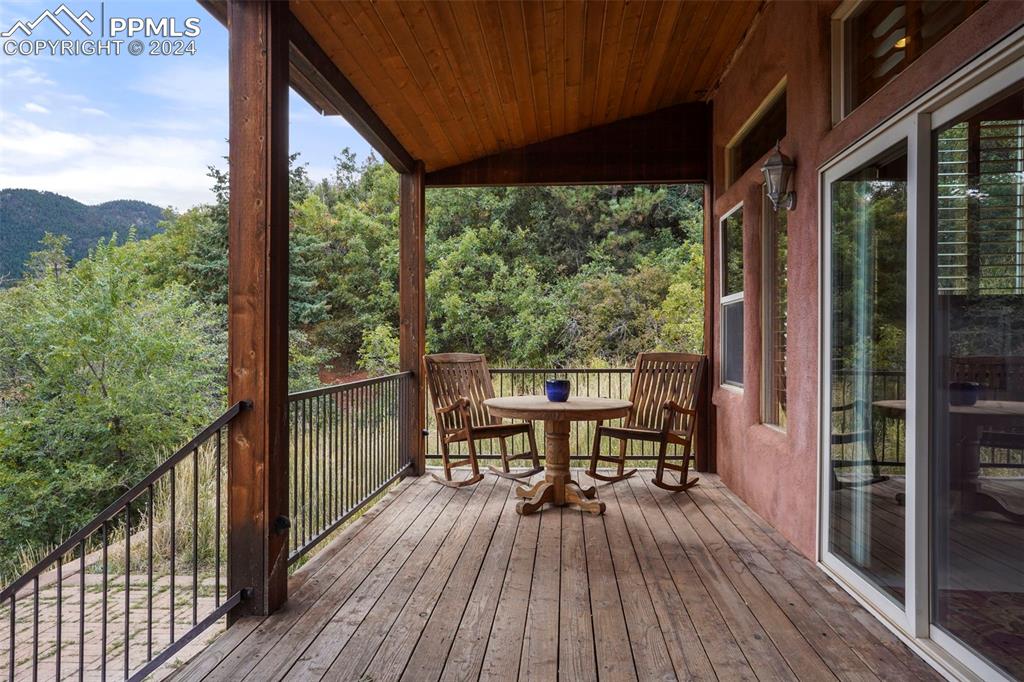 915 Oak Ridge Road Manitou Springs, CO 80829 - Photo 36 of 50 a view of a balcony with chairs and wooden floor
