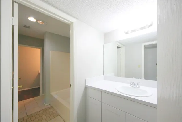 a bathroom with a sink a mirror and a bathtub