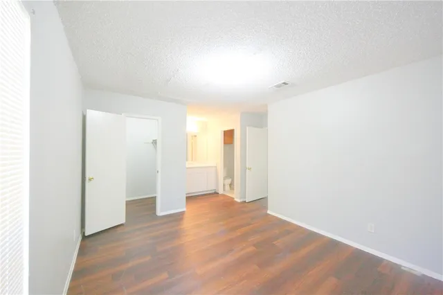 a view of a big room with wooden floor and windows