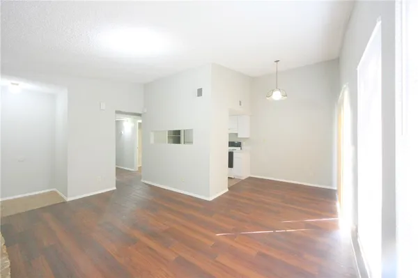 a view of empty room with wooden floor