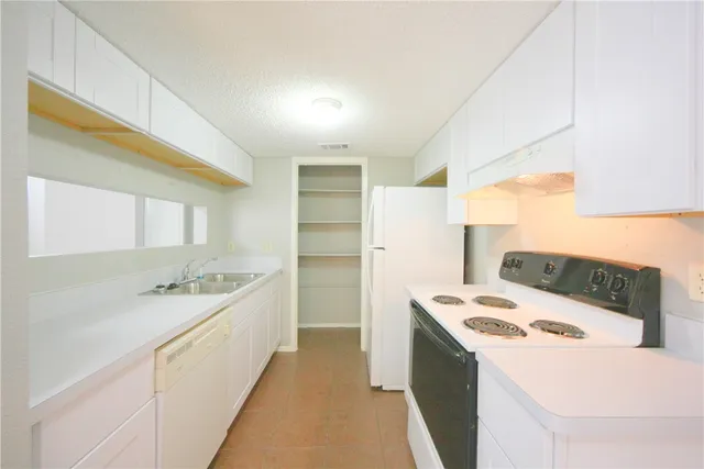 a kitchen with a sink a stove a refrigerator and a window