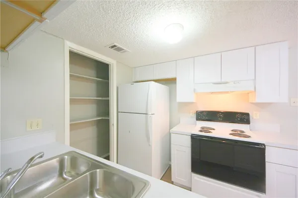 a kitchen with white cabinets and white appliances