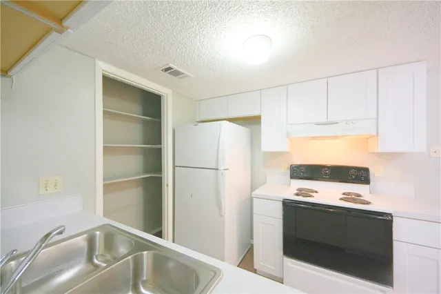 a kitchen with white cabinets and white appliances