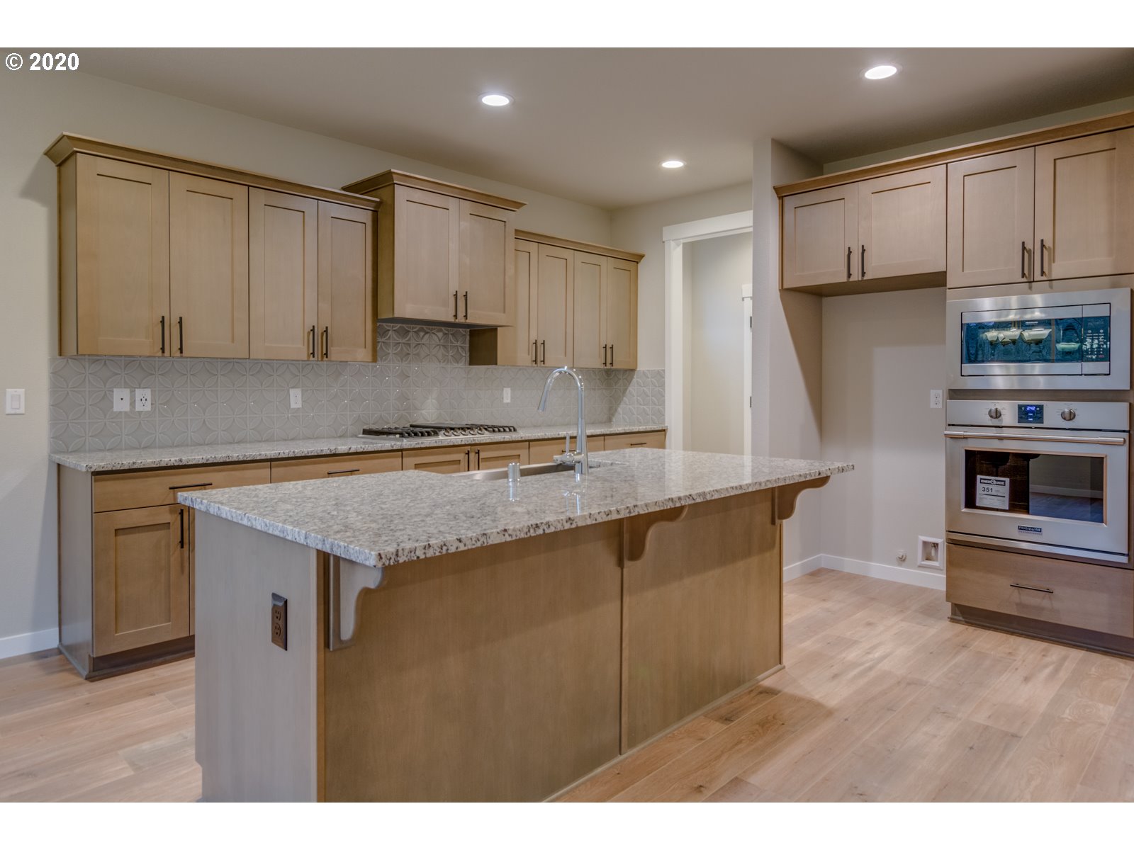 8524 North 1st Street, Unit LT96 Ridgefield, WA 98642 - Photo 13 of 32 a kitchen with kitchen island granite countertop a stove a sink and a refrigerator